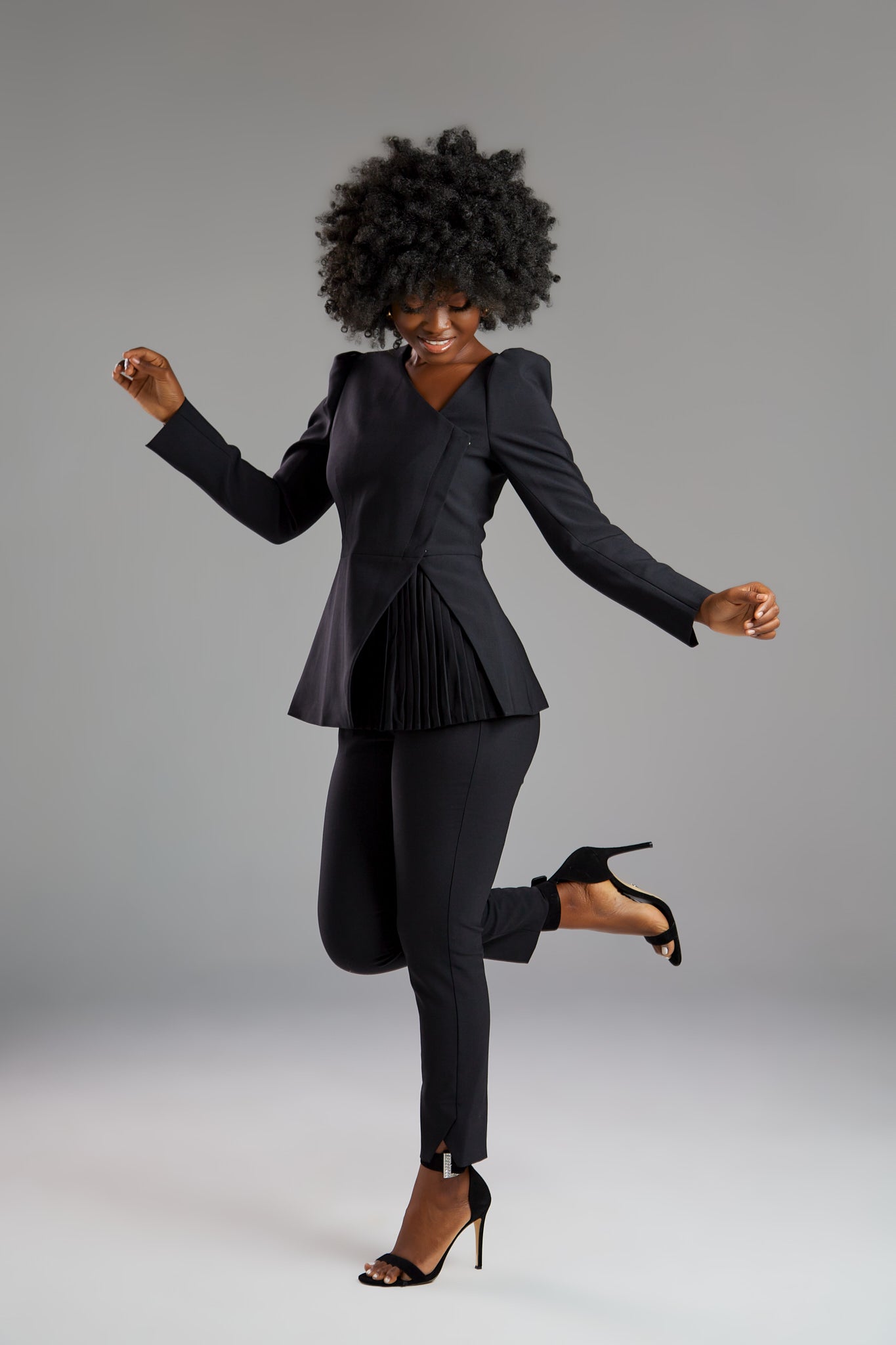 Seragyi's Liz Peplum Jacket in Women's Clothing line, made of wrinkle-resistant Italian Merino wool, showcasing Women's Jackets' sophistication, quality, and sustainability. A prime example of Women's Suits, it features an asymmetrical neckline, pyramid-cut sleeves, and a partially pleated peplum. Ideal for travel and versatile styling, from monochrome looks to skinny jeans and heels for evening wear.