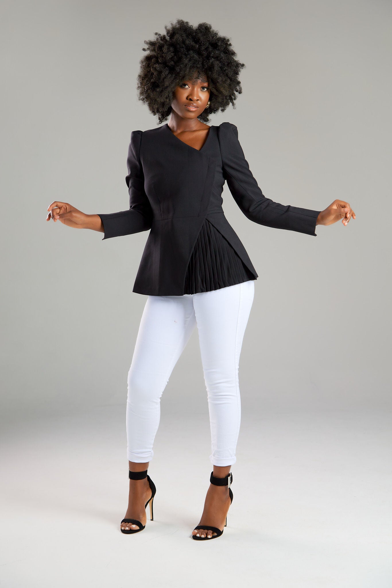 Seragyi's Liz Peplum Jacket in Women's Clothing line, made of wrinkle-resistant Italian Merino wool, showcasing Women's Jackets' sophistication, quality, and sustainability. A prime example of Women's Suits, it features an asymmetrical neckline, pyramid-cut sleeves, and a partially pleated peplum. Ideal for travel and versatile styling, from monochrome looks to skinny jeans and heels for evening wear.